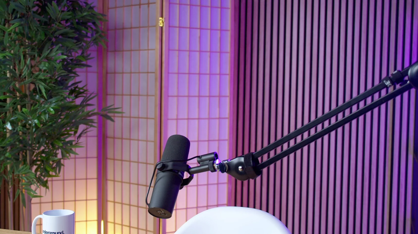 Décor de studio podcast avec micro, ambiance bleu nuit.